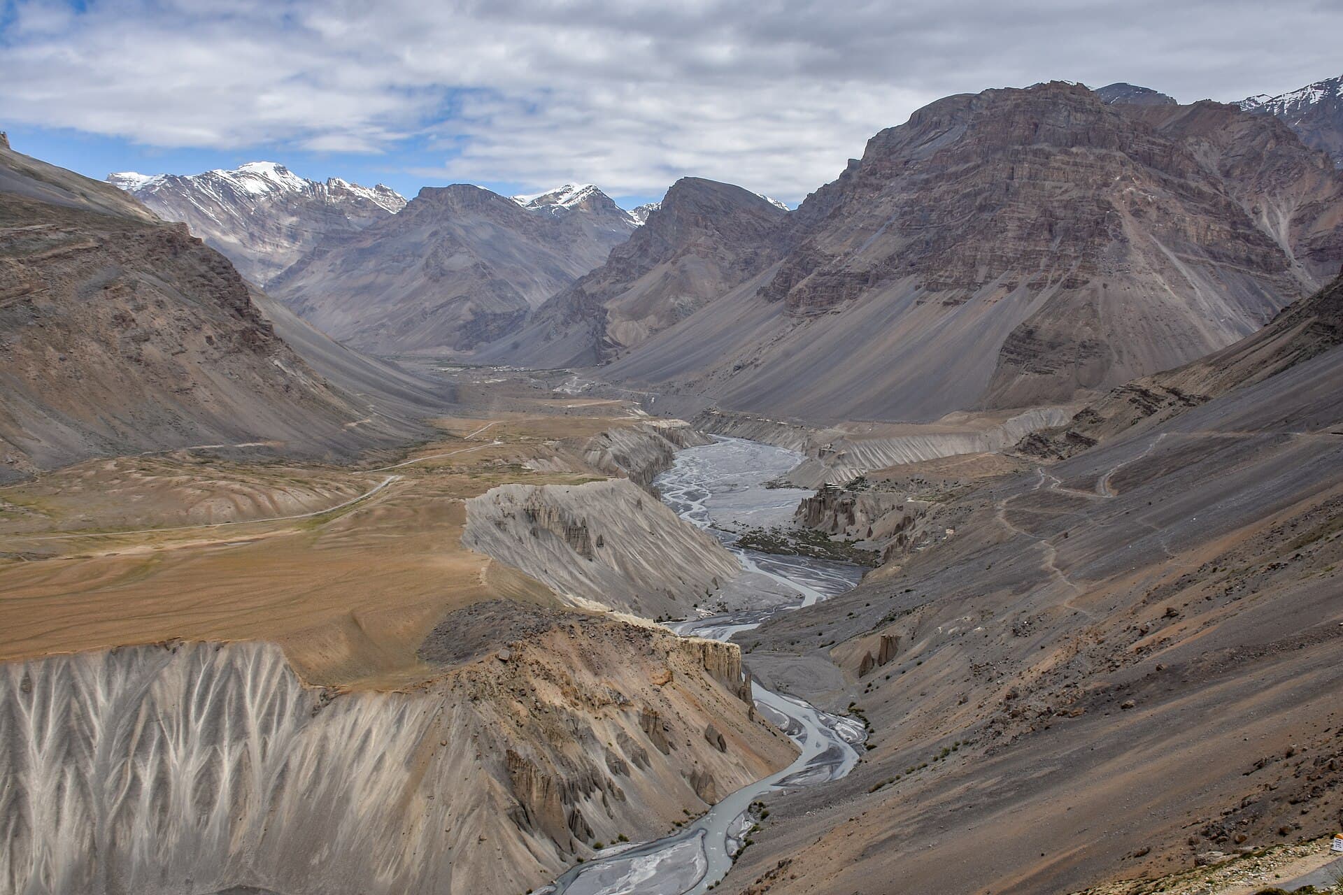 The bare, high-altitude road through the Spiti valley below rock ridges